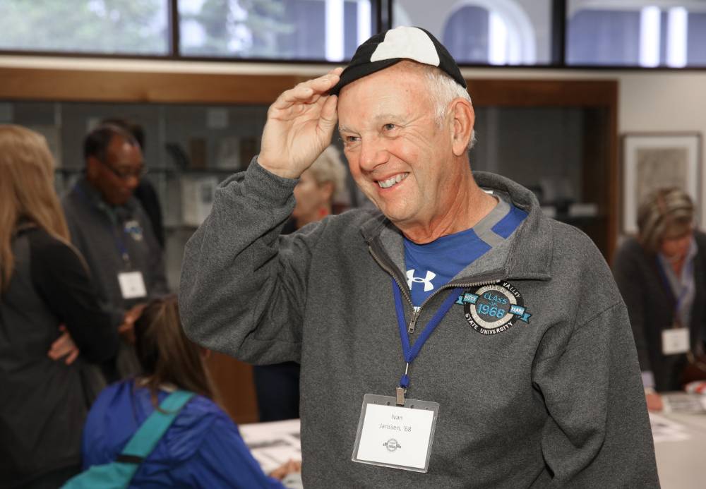 An alumnus wearing a hat from when he was a student in 1968.